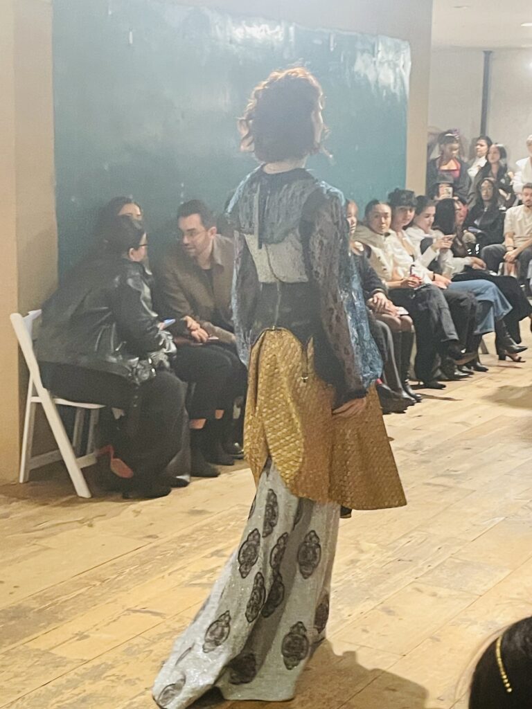 Model on the runway wearing beautiful clothing.